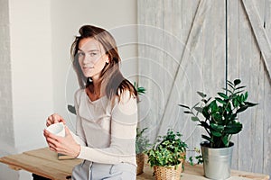 Beautiful young feminine woman relaxing at home in lazy weekend morning with cup of coffee