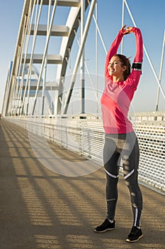 Beautiful young fit woman stretching after working out outside o