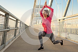 Beautiful young fit woman working out outside on a bridge