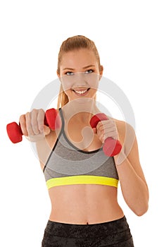 Beautiful young fit woman works out with dumbbells isolated over