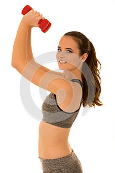 Beautiful young fit woman works out with dumbbells isolated over