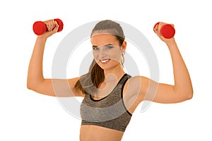 Beautiful young fit woman works out with dumbbells isolated over