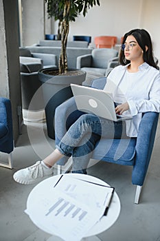 Beautiful Young Freelancer Woman Using Laptop Computer Sitting At Cafe Table. Happy Smiling Girl Working Online Or