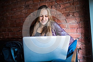 Beautiful Young Freelancer Woman Using Laptop Computer Sitting At Cafe Table. Happy Smiling Girl Working Online Or Studying And Le