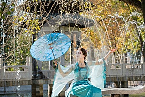 Beautiful young geisha with a blue umbrella