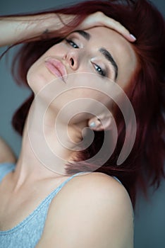 Beautiful young ginger woman with freckles. Fashion portrait of charming girl wearing casual clothes posing at home