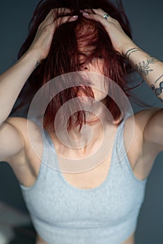 Beautiful young ginger woman with freckles. Fashion portrait of charming girl wearing casual clothes posing at home