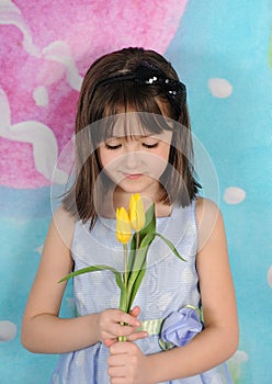 Beautiful young girl admiring tulips at easter