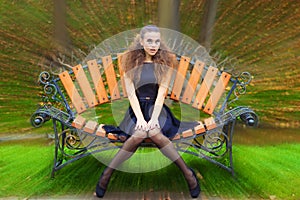 Beautiful young girl autumn day on the street with fantasy makeup in a black dress with big lips sitting on a bench