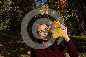 Beautiful young girl in the autumn forest on a sunny day