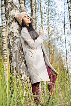 Beautiful young girl in the autumn forest on a sunny day