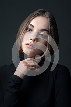 Beautiful young girl on a background of dark shadows, looking questioning look