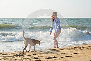 Beautiful young girl on the beach with her dog