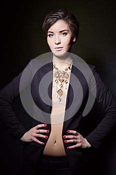 Beautiful young girl with beautiful stylish expensive jewelry, necklace, earrings, bracelet, ring, filming in the Studio