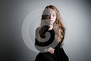 Beautiful young girl in black 1890s English Victorian 18th century child period dress with elegant white lace collar