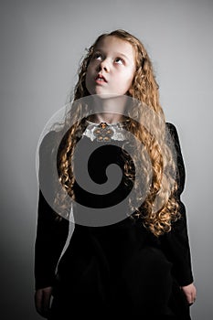 Beautiful young girl in black 1890s English Victorian 18th century child period dress elegant white lace collar antique broach