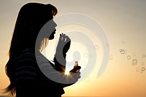 Beautiful young girl blow bubbles on nature