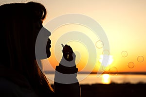 Beautiful young girl blow bubbles on nature