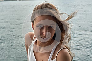 Beautiful young girl with brown hair and awesome eyes on the ocean beach in the metropolis Hong Kong