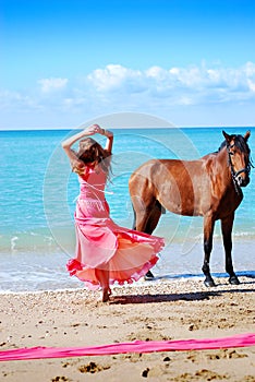 The beautiful young girl dances on coast