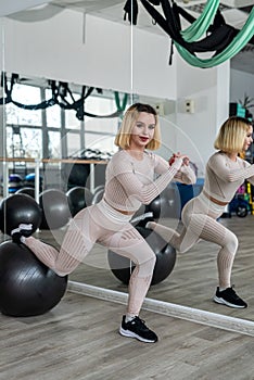 beautiful young girl doing exercises on a fitness ball in a sports hall.