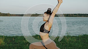 Beautiful young girl doing yoga in morning at lake. Healthy lifestyle concept