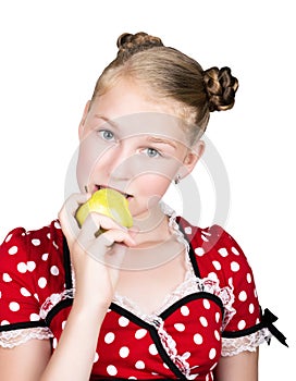 Beautiful young girl dressed in a red dress with white polka dots eating an apple. healthy food - strong teeth concept
