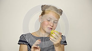 Beautiful young girl dressed in a striped dress eating an apple. healthy food - strong teeth concept