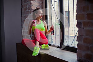 Beautiful young girl is drinking a fitness smoothie. Healthy lifestyles concept.