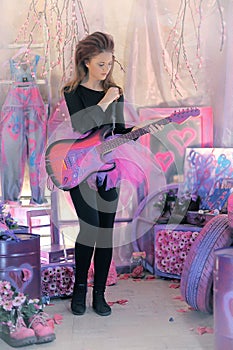Beautiful young girl with electric guitar.