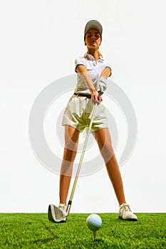 Beautiful young girl in elegant clothes, concentrated gold player standing with golf club and preparing to hit isolated