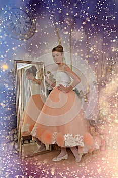 Beautiful young girl with evening haircut in pink with white a  lash by a gilded mirror, fitting