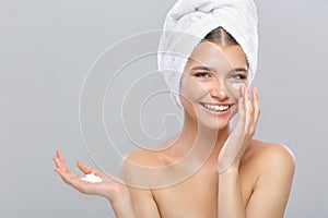 Beautiful young girl with face cream is laughing