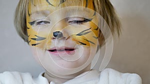 Beautiful young girl with face painted like a tiger