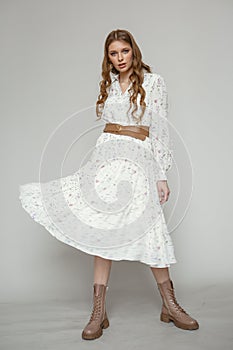 Beautiful young girl in flying white dress. Flowing fabric. Light white cloth flying in the wind