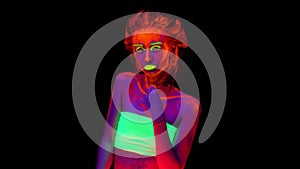 A beautiful young girl with glowing paint on her body in black light. Pretty woman with glowing bodyart in black
