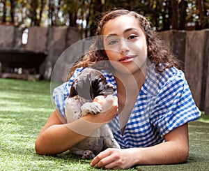 Beautiful young girl having fun with her small French Braque puppies