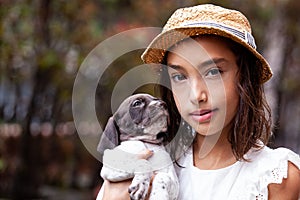 Beautiful young girl having fun with her small French Braque puppy