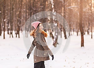 Beautiful young girl having fun in winter in the park on a sunny day