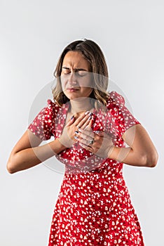 beautiful young girl holds her hands to her chest feeling sharp pain.