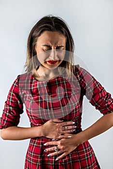 beautiful young girl holds her stomach, which has spasms.