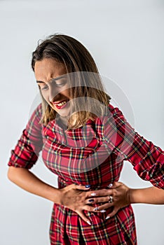 beautiful young girl holds her stomach, which has spasms.