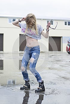 Beautiful young girl jumped into a puddle.