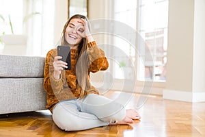 Beautiful young girl kid sending a message using smartphone with happy face smiling doing ok sign with hand on eye looking through