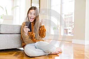 Beautiful young girl kid sending a message using smartphone screaming proud and celebrating victory and success very excited,