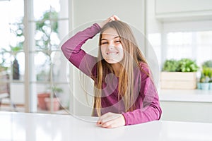 Beautiful young girl kid on white table confuse and wonder about question