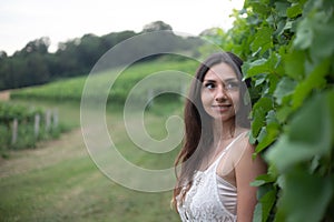 Beautiful young girl leans into the vineyard wires and gets a nice photo shoot