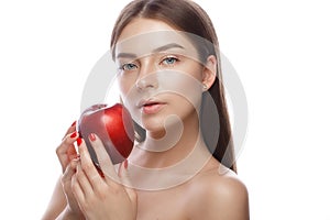 Beautiful young girl with a light natural make-up and perfect skin with apple in her hand . Beauty face.