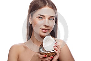 Beautiful young girl with a light natural make-up and perfect skin with coconut in her hand . Beauty face.