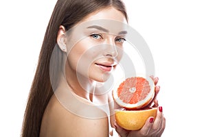 Beautiful young girl with a light natural make-up and perfect skin with Grapefruit in her hand . Beauty face.